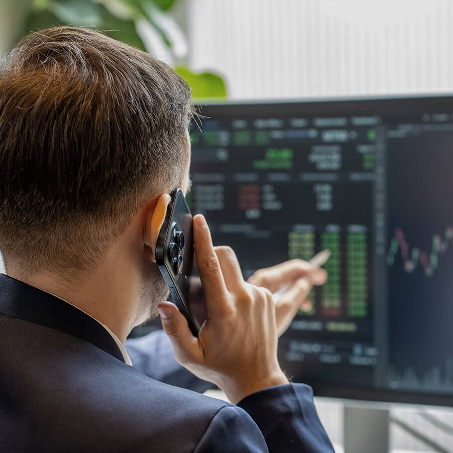 Persona che analizza dati finanziari al telefono con il proprio Advisor. 