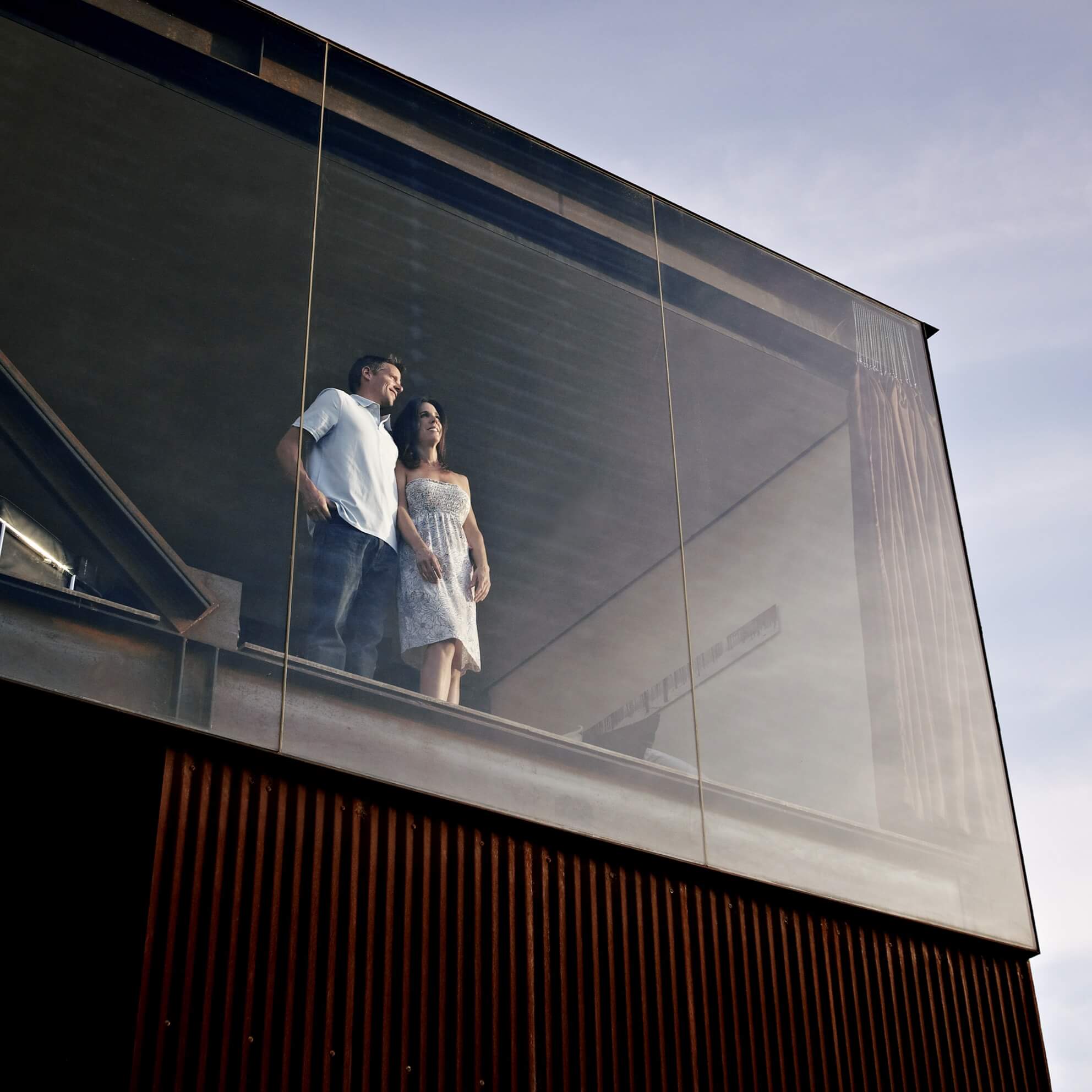 Coppia che osservano dalla finestra di una casa dopo aver sottoscritto l'Assicurazione Vita abbinata ai Mutui Mediobanca Premier