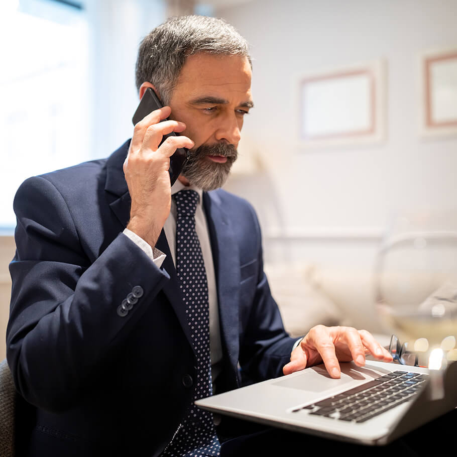 Persona che consulta l'andamento degli investimenti da un computer al telefono con il proprio Advisor.